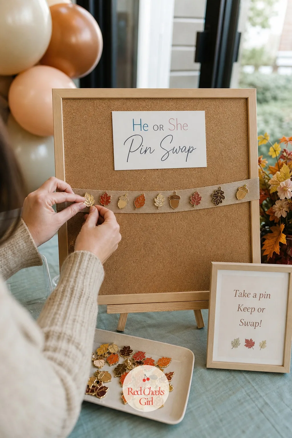 He or She Pin Swap Station — A tray of plain enamel pins, a leaf shape for one guess, an acorn for the other, turns guessing into something guests wear for the