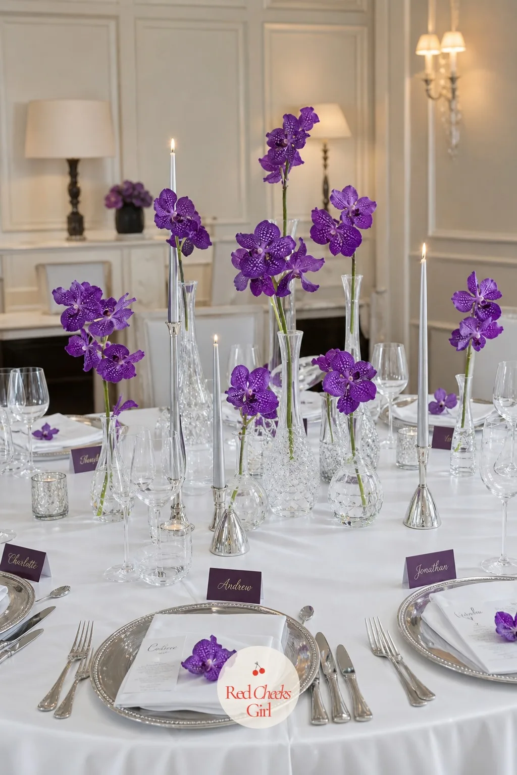 Violet Orchids in Single-Flower Arrangements on White Tables — A dinner table buried under a full centrepiece makes conversation across it impossible, and she