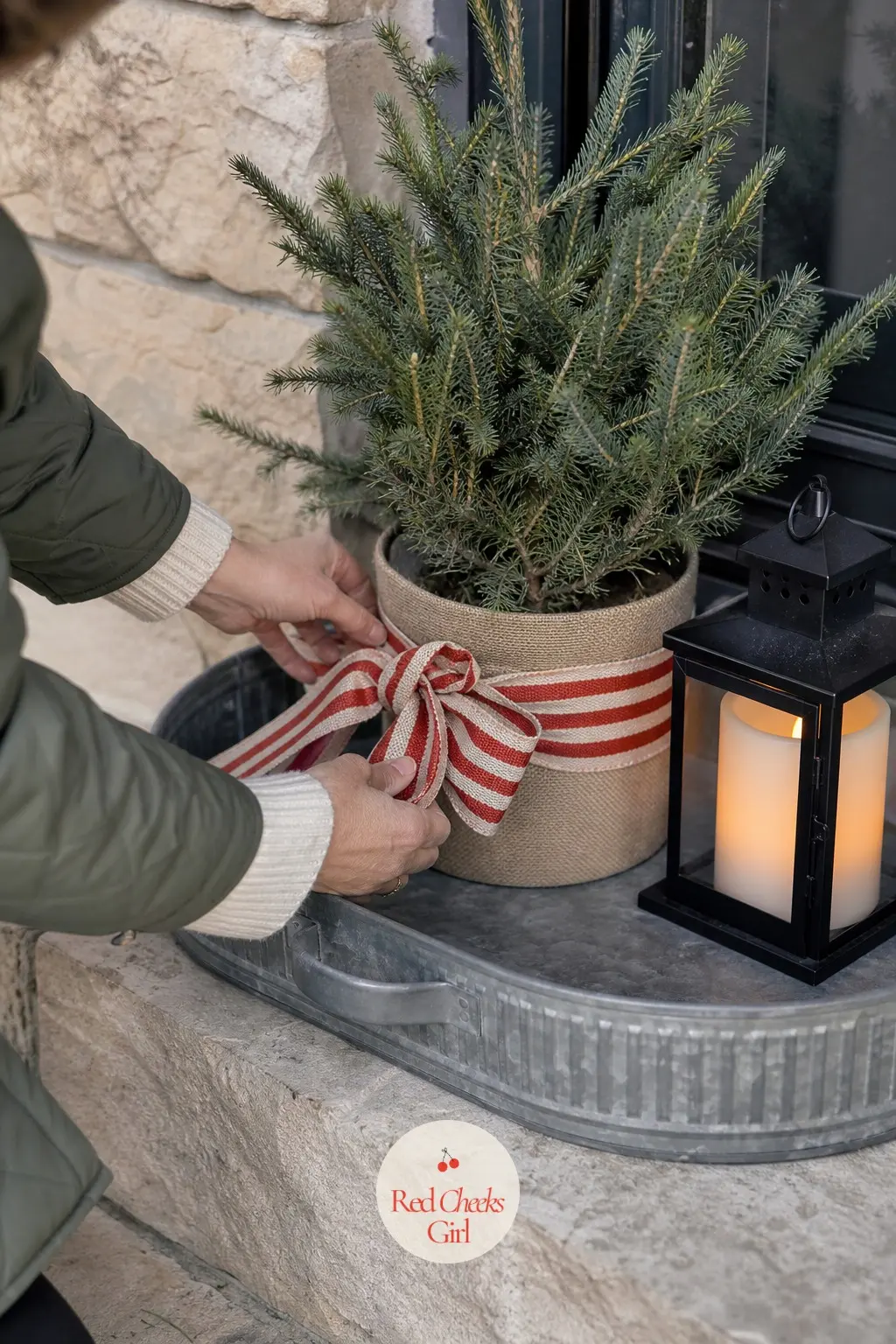 A Boot Tray Entry Station Dressed with a Potted Spruce and a Striped Ribbon — A galvanized boot tray by the step holds a small potted spruce wrapped in a wide