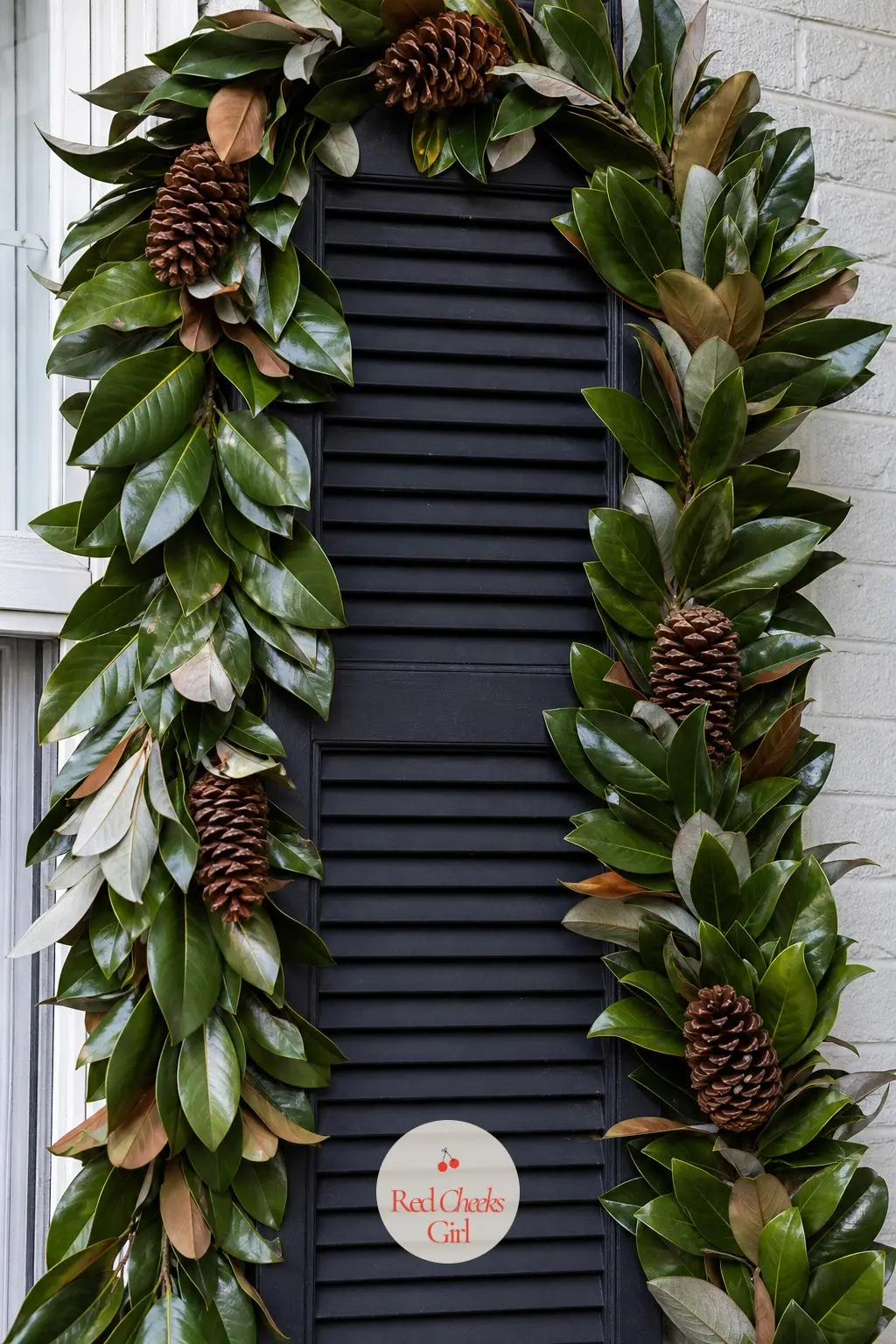 Shutters Flanked by Magnolia Leaf Garland with Natural Pinecones — Glossy dark magnolia leaves, with their silvery undersides, drape around the shutters