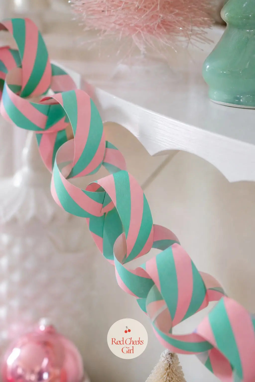 1950s Pink and Mint Paper Chain — Diagonal diner stripes in pink and mint, the two colours trading places strip to strip so the chain has movement rather than