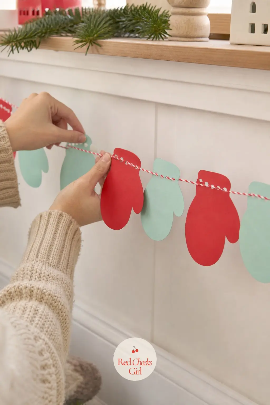 Red and Mint Mittens Paper Chain — Mitten shapes alternating red and mint, each with a simple cuff line and a few stitch marks drawn in, strung flat along a