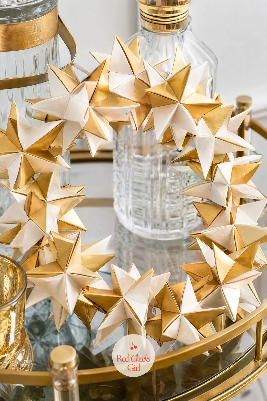 The Gold and Ivory Folded Star Garland Wreath for the Bar Cart — Folded paper stars, gold next to ivory, get threaded onto a long garland string first, then