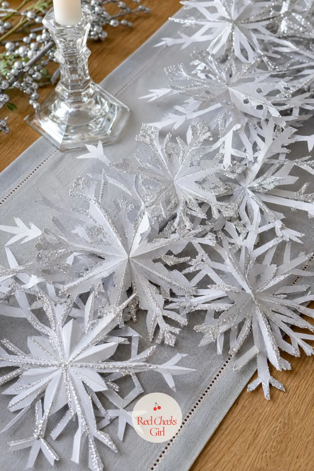 The Pale Grey and Crystal Glitter Snowflake Spray Wreath for the Foyer Table — Instead of a closed ring, this one wires loose paper snowflakes, pale grey edged