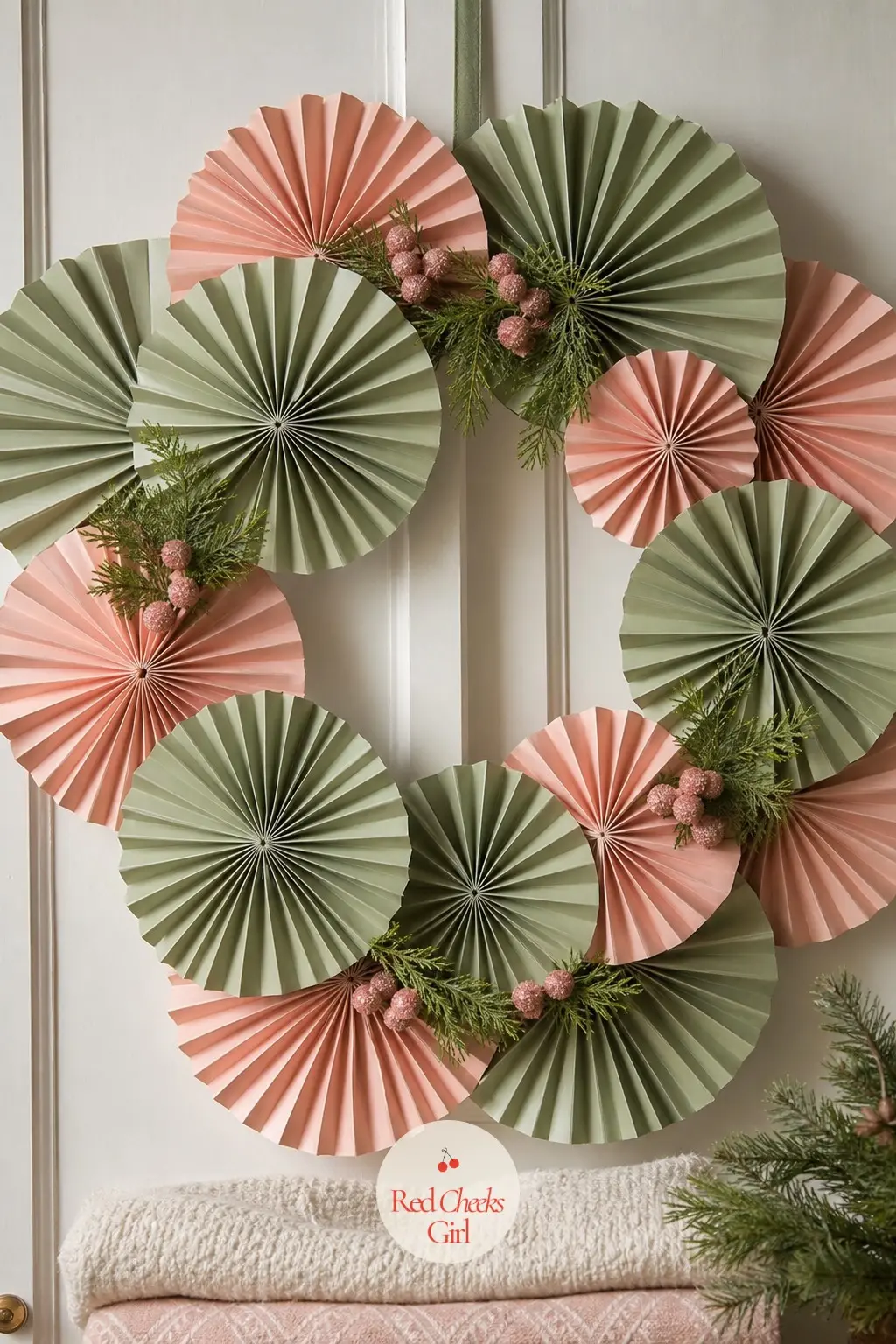 The Sage and Blush Pleated Paper Fan Wreath for the Linen Closet Door — Strips of sage and blush paper pleat back and forth, then fan open at one end and pinch
