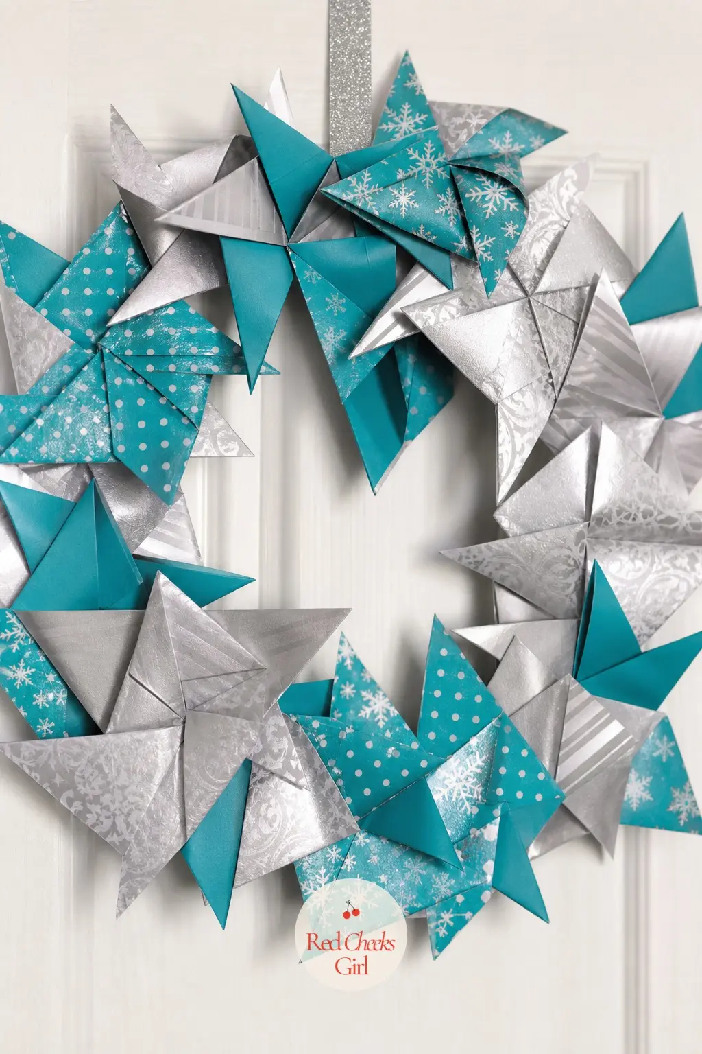 The Teal and Silver Pinwheel Star Wreath for the Craft Room Door — Each fold here opens into a pinwheel rather than a closed star, teal paper backed with a