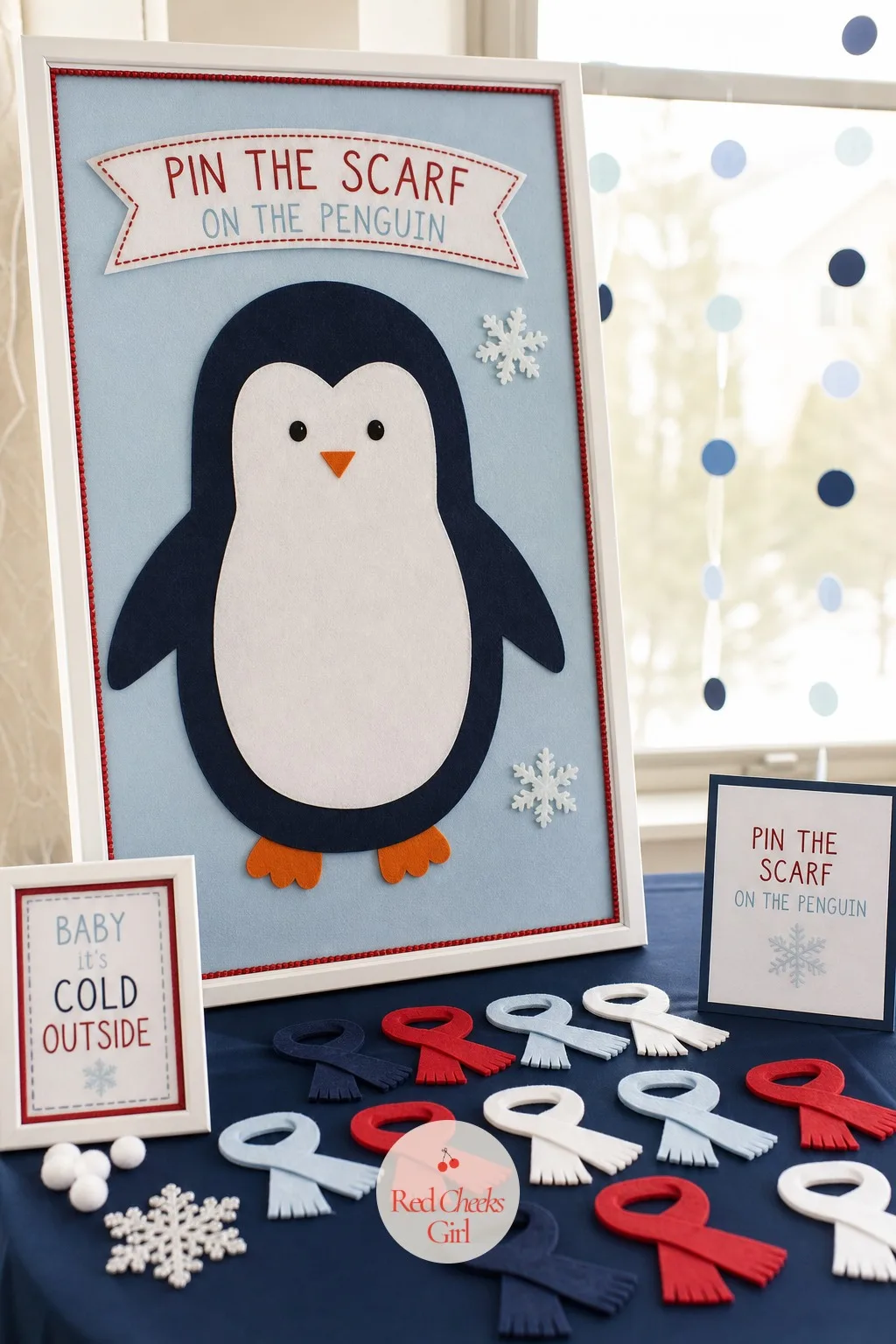 Pin the Scarf on the Penguin — This one photographs as itself: a felt board, a scarfless penguin, a pile of tiny scarves waiting to be placed. Penguin baby