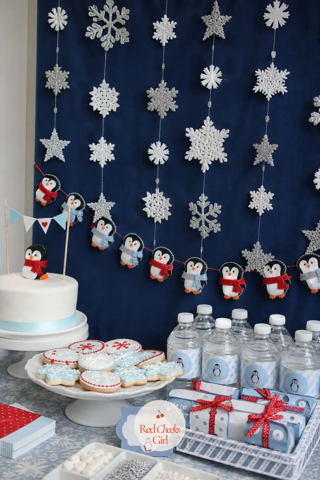 Snowflake Garland Photo Backdrop — A bare wall behind the dessert table shows up in every photo whether you planned for it or not. Penguin baby shower ideas