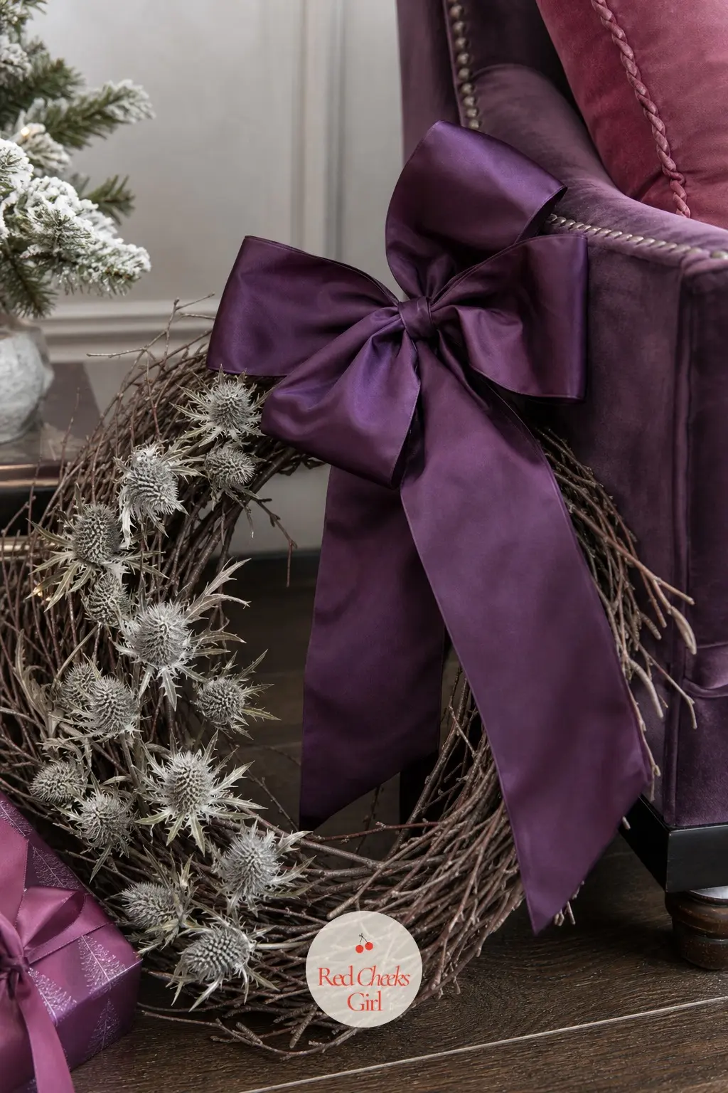 The Amethyst Taffeta Bow and Silver Thistle Wreath for the Velvet Armchair Corner — A deep amethyst taffeta bow sits above dried silver thistle heads on a bare