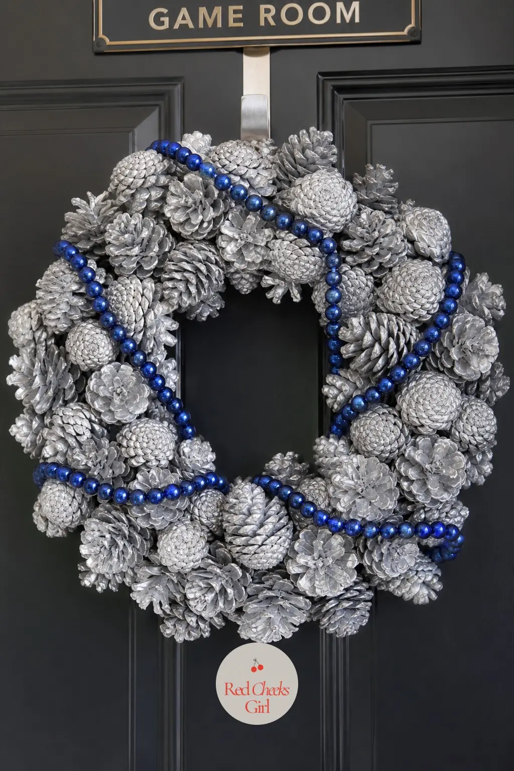 The Sapphire Bead Garland and Silver Pinecone Wreath for the Game Room Door — Deep sapphire bead garland winds twice around a ring studded with pinecones