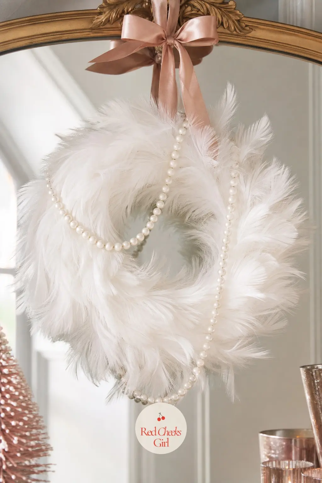 The White Feather and Pearl Strand Wreath for the Powder Room Mirror — Soft white feathers cover the ring in overlapping layers with a single long pearl strand