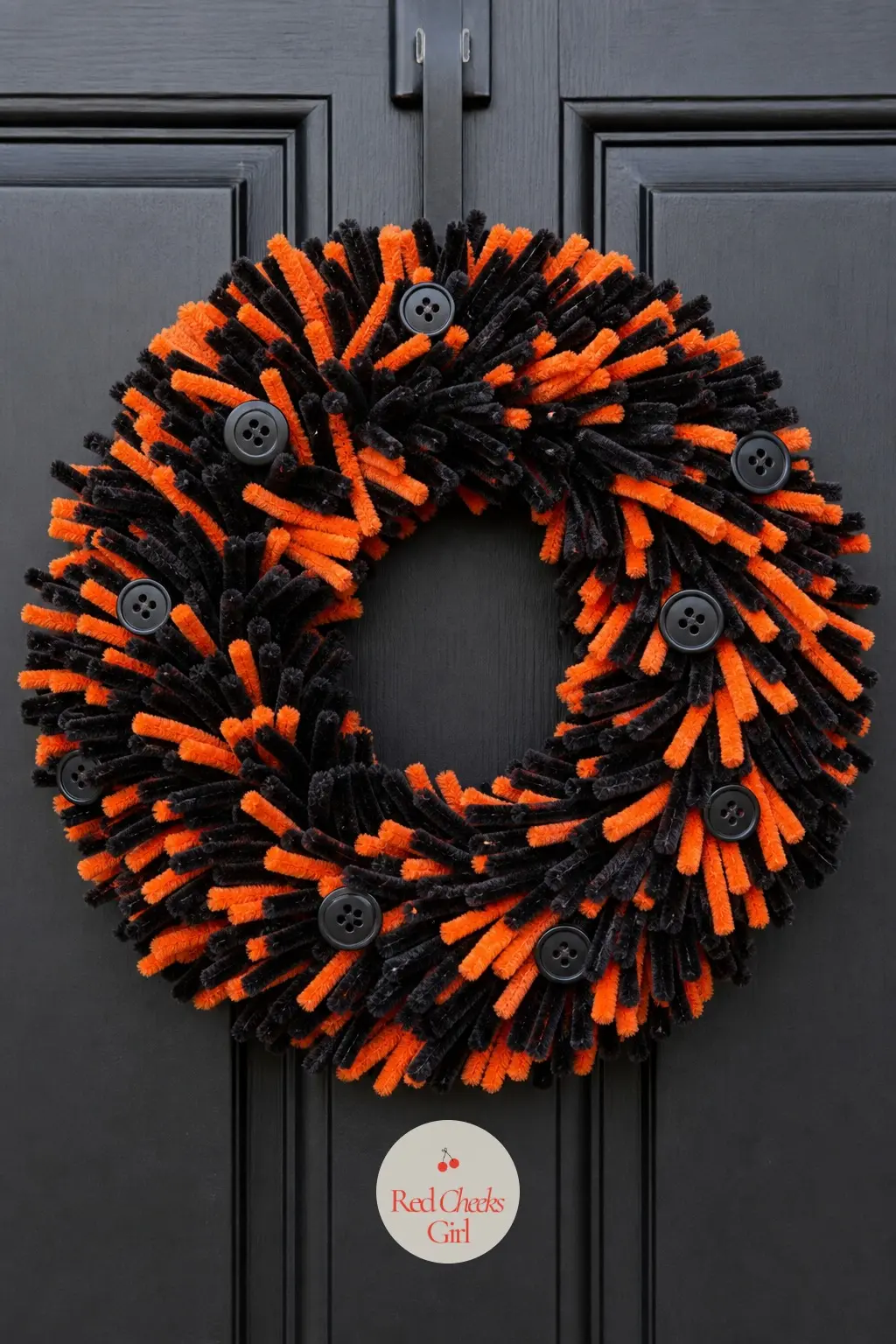 The Black and Orange Coil Door Wreath for the Halloween Porch — Jet black and bright orange pipe cleaners alternate in thick bands around the frame, which