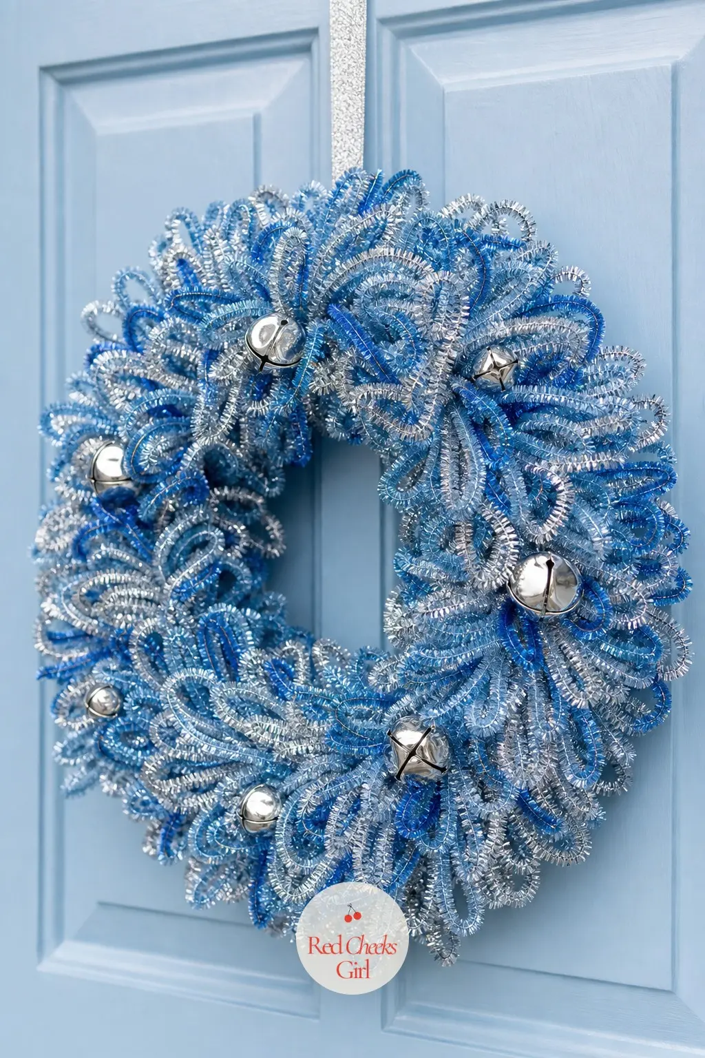 The Icy Blue and Silver Coil Door Wreath for the Winter Welcome — Pale icy blue and metallic silver pipe cleaners alternate in bands around the frame rather