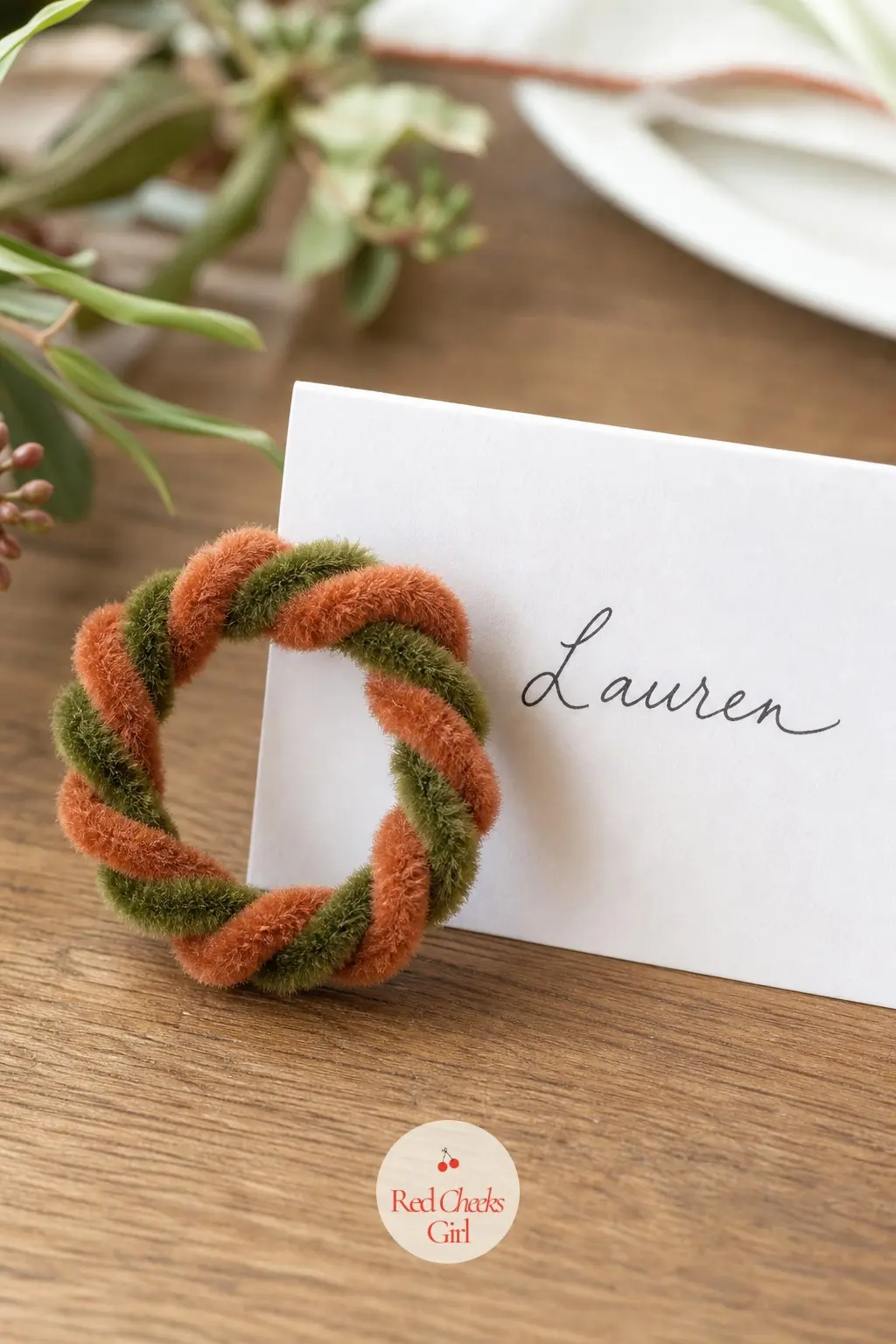 The Terracotta and Moss Coil Wreath for the Place Card Setting — Terracotta orange and moss green pipe cleaners coil together into a ring small enough to sit