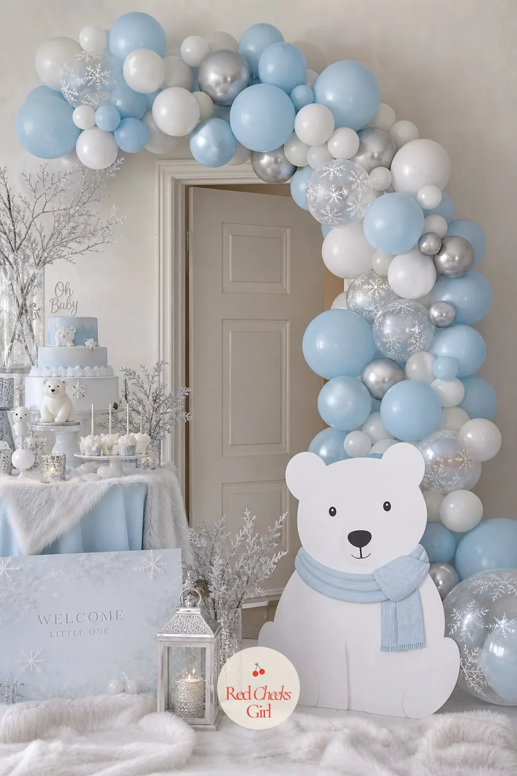 Blue, White and Silver Balloon Arch — An organic balloon arch in three tones, deep icy blue, white and chrome silver, curves over the dessert table or the