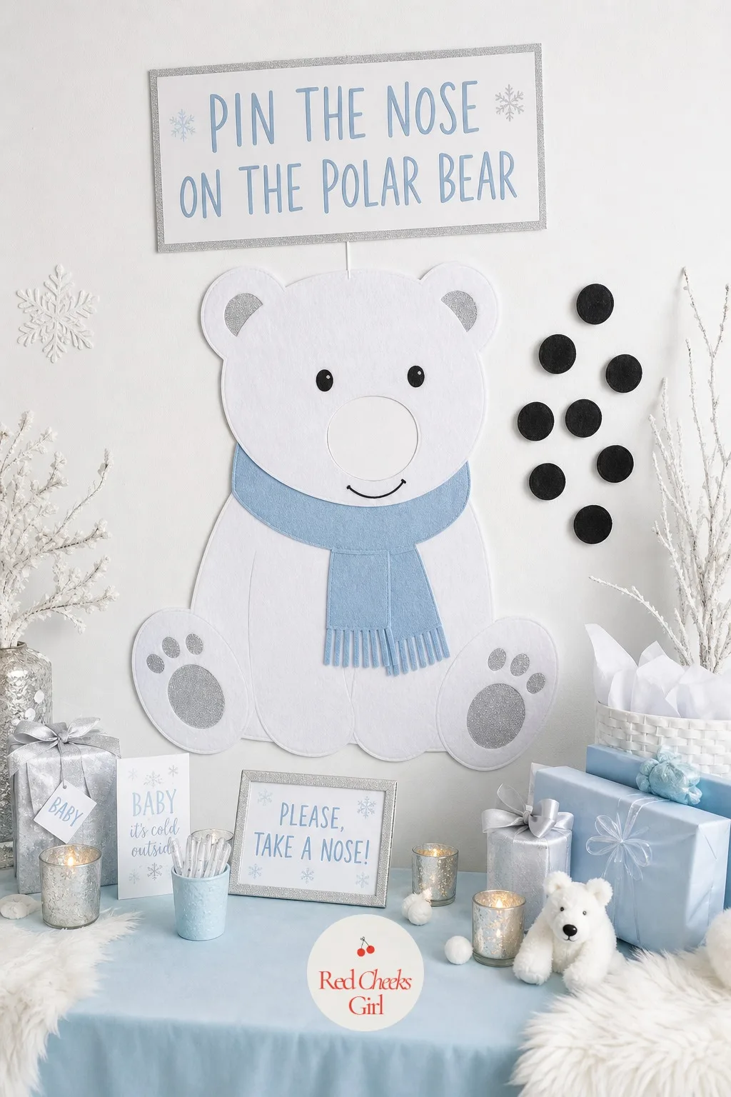 'Pin the Nose on the Polar Bear' Game — A large white felt or paper polar bear, nose left blank, hangs on the wall or stands on an easel. Polar bear baby