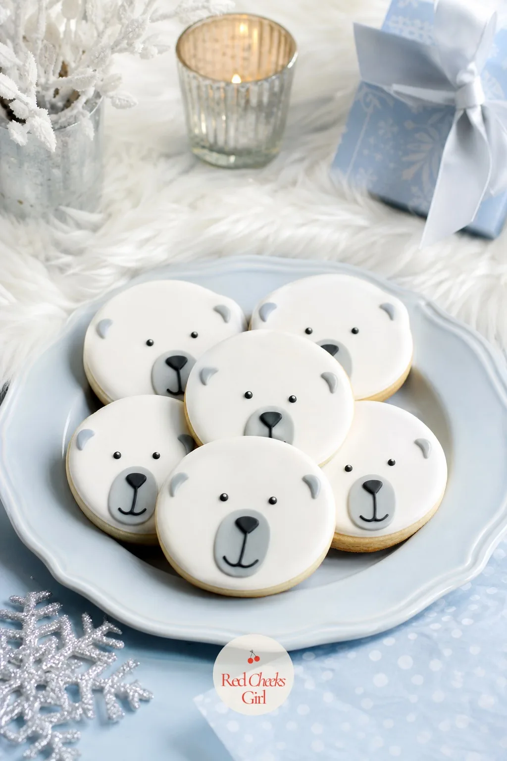 Polar Bear Face Sugar Cookies — Round sugar cookies iced flat in white with two small black royal icing dots for eyes and a grey outline for the muzzle, piped