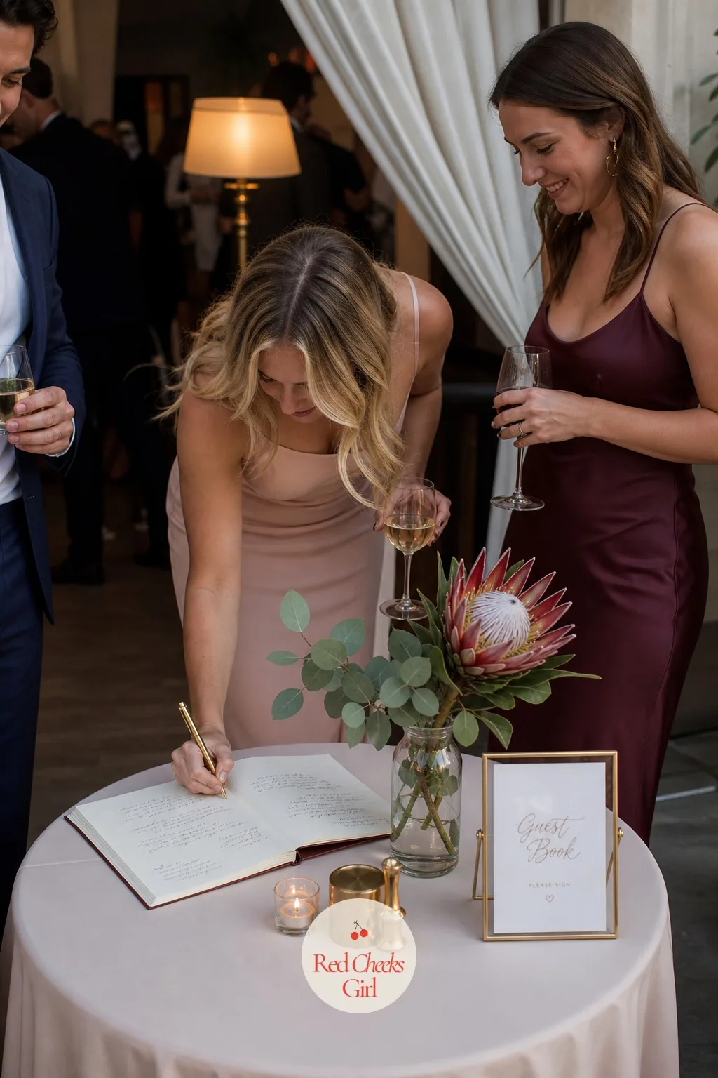 A Guest Book Table Styled With Protea — Tucked near the entrance to the reception, a small side table holds the guest book, pen and a single protea stem so