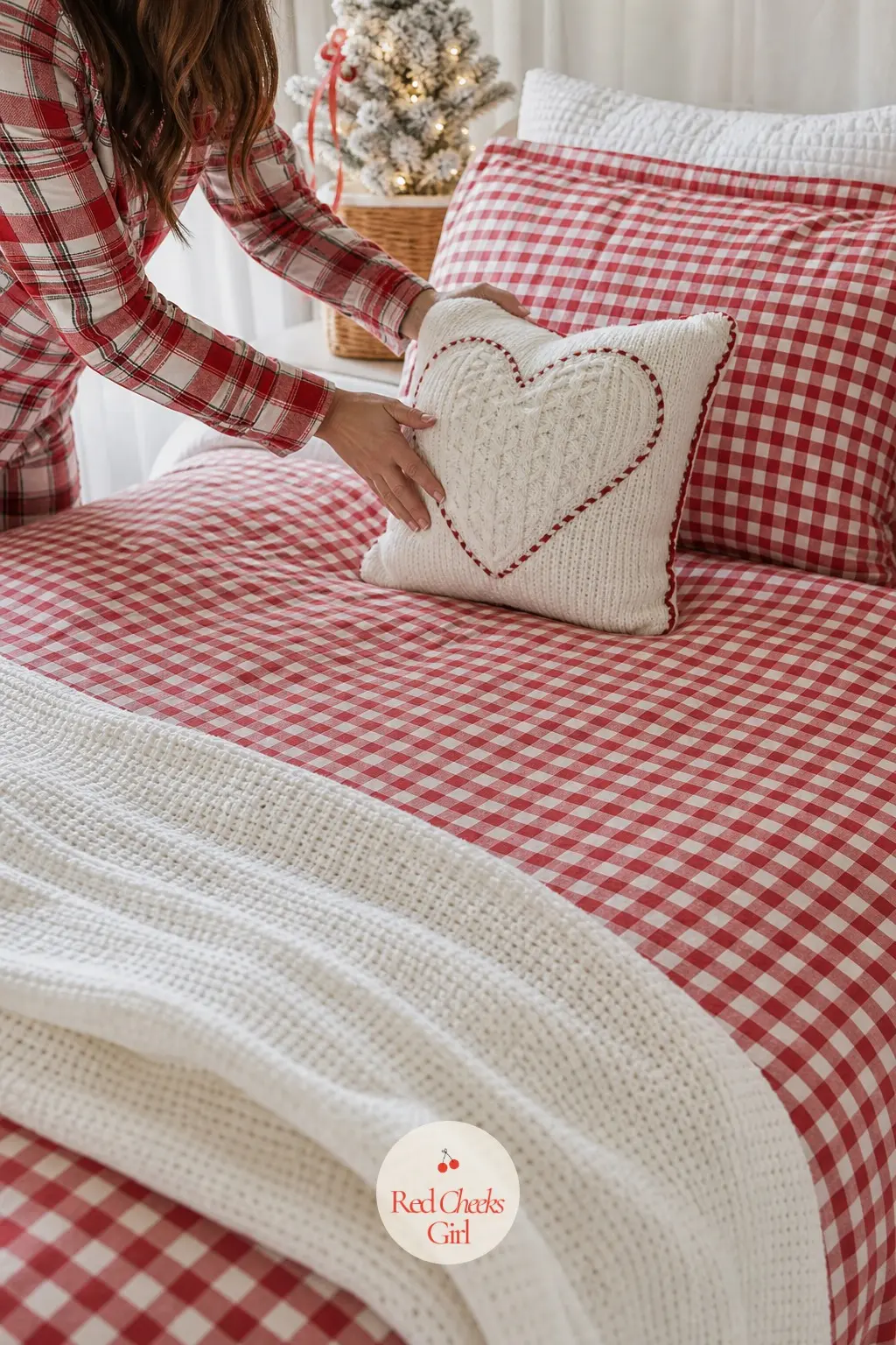 The Guest Bed — A red gingham duvet cover sits under a folded white waffle weave blanket at the foot of the bed, with one Nordic heart throw pillow leaning