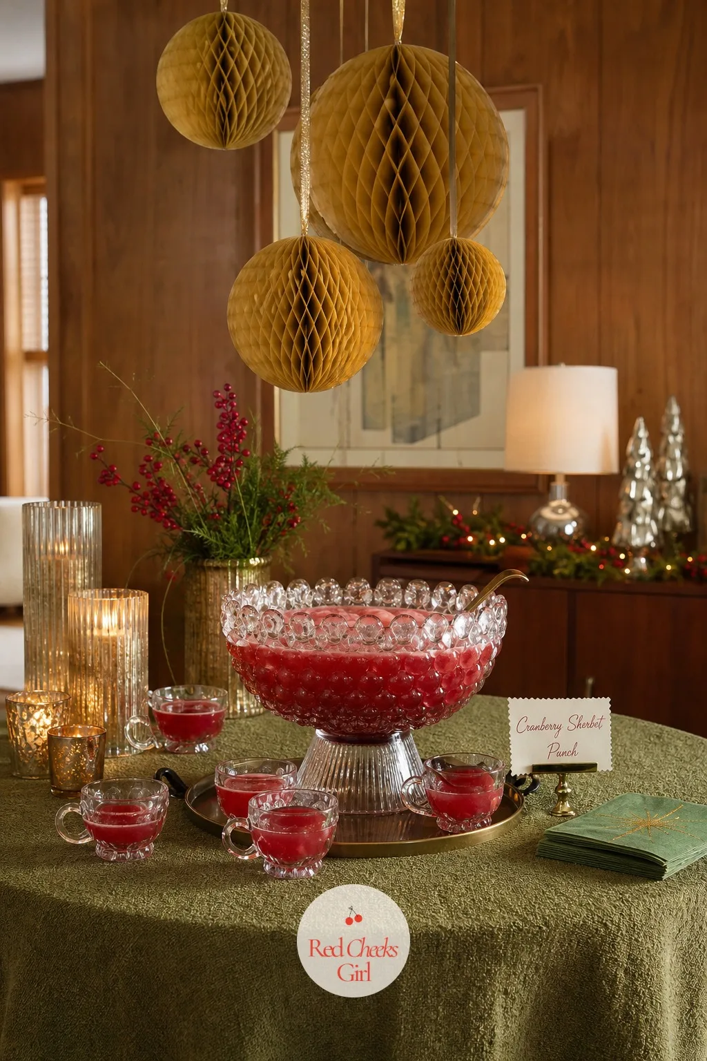 The Punch Table Under Paper Honeycomb — A single glass punch bowl does more work than any other object on this list: it gives guests a reason to gather in one