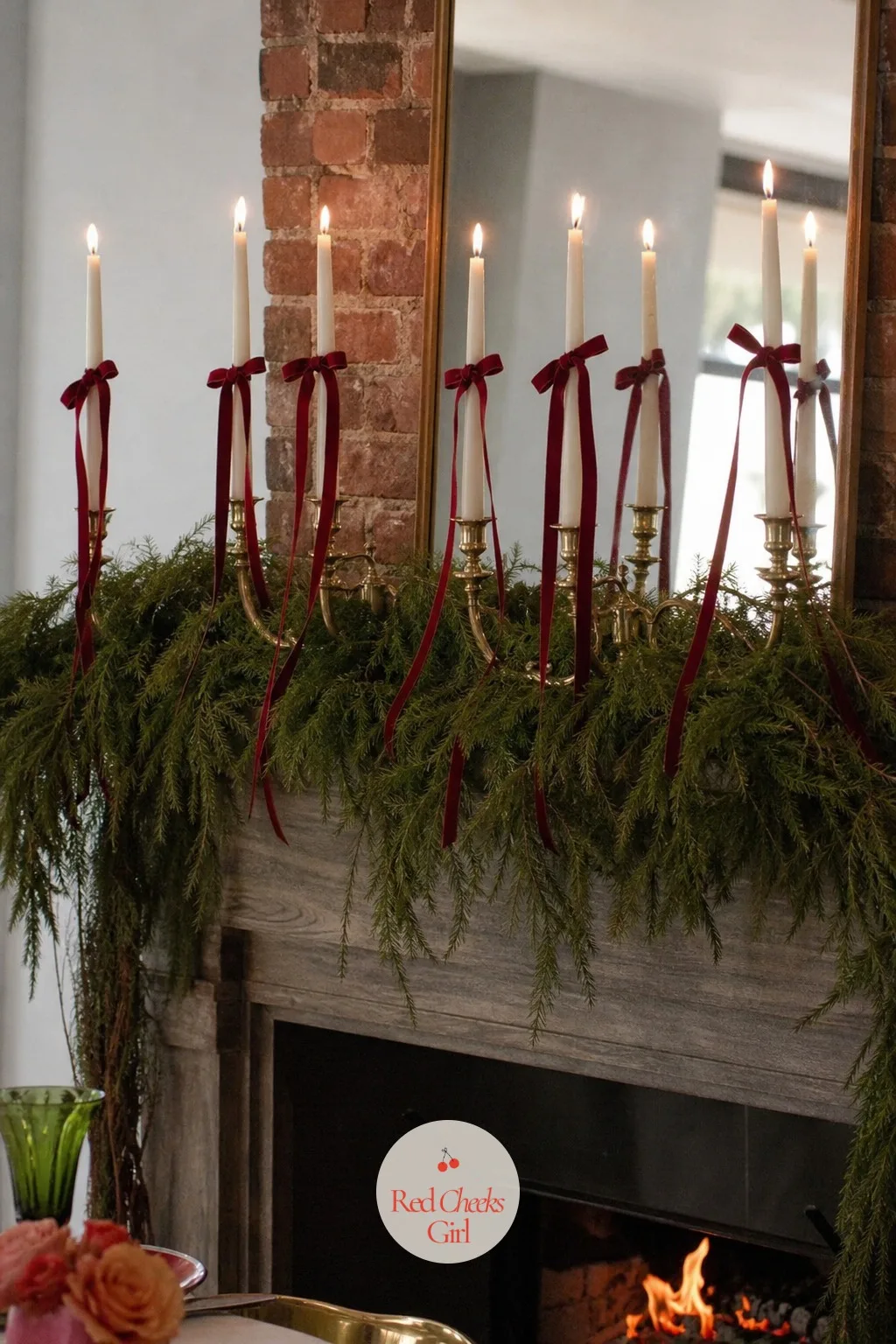 Narrow Velvet Ribbon Ties on Every Candle Along the Mantel — A brass candelabra on a bed of cedar does most of the work on its own, but a few inches of dark