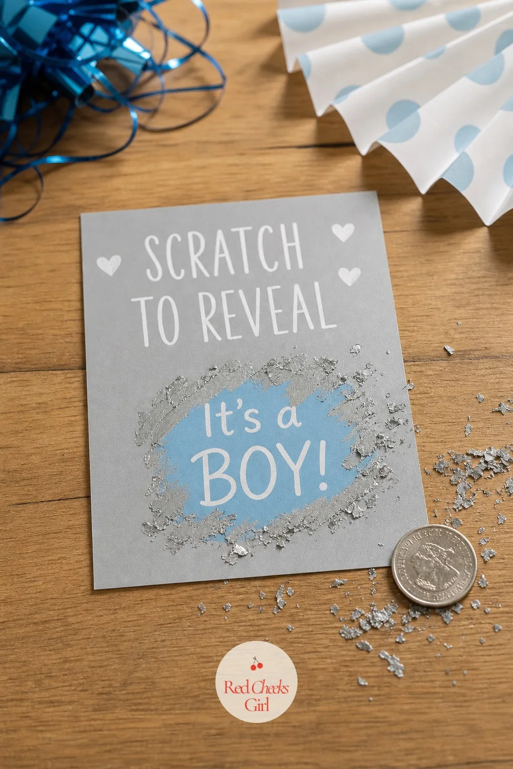 The Scratch-Off Reveal Card — A small silver card sits in her hand, and underneath the coating she scrapes away with a coin is the colour nobody in the room