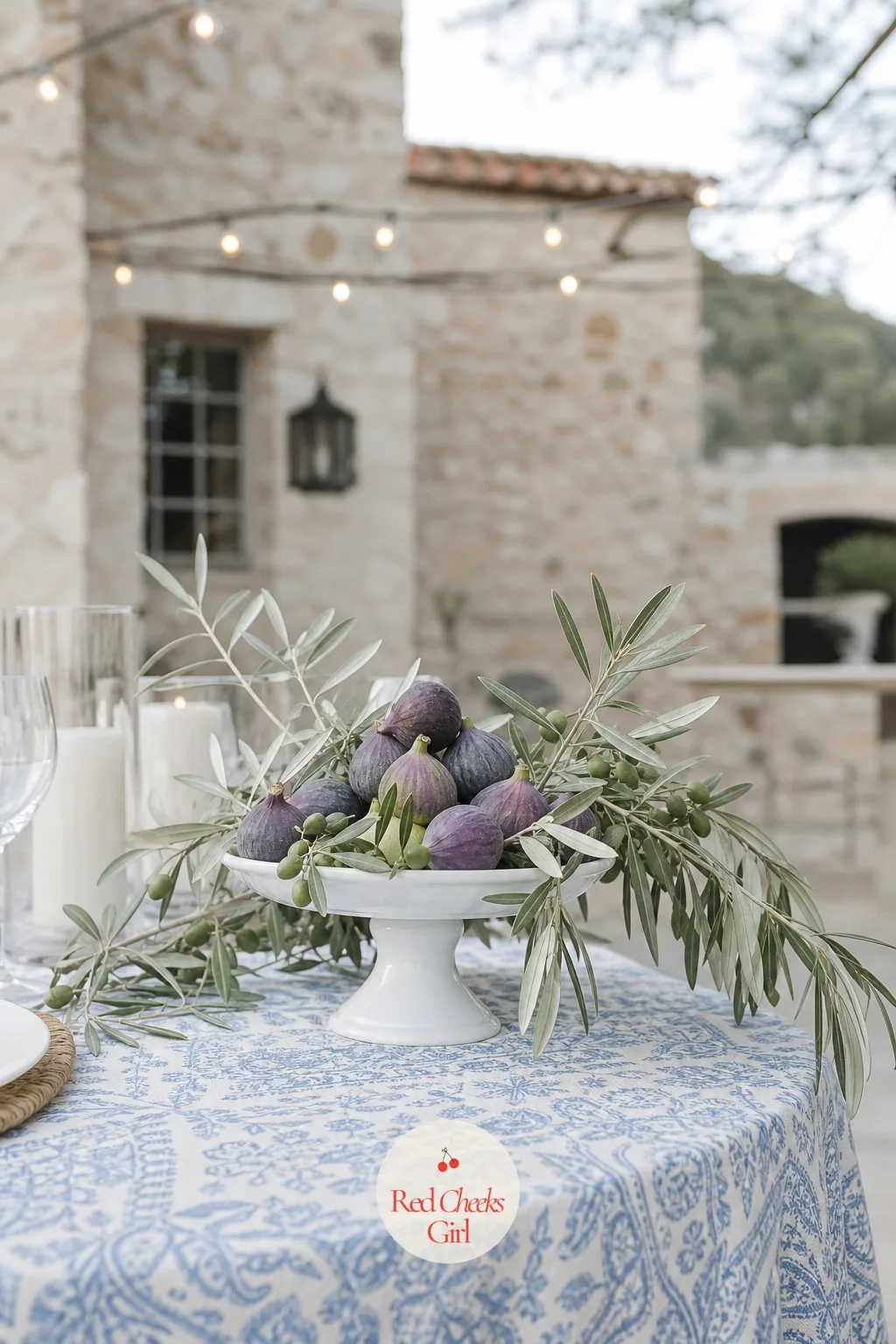 Fresh Figs and Olive Branches on a Footed Dish — A Mediterranean-leaning reception can skip flowers entirely and still look lush, built instead from fruit and