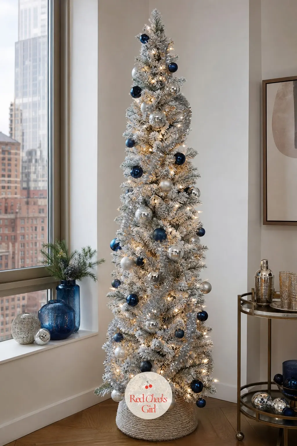 A Slim Flocked Tree in Midnight and Chrome — An artificial flocked slim pencil tree, white underneath with a midnight blue dressing layered on top, which gives
