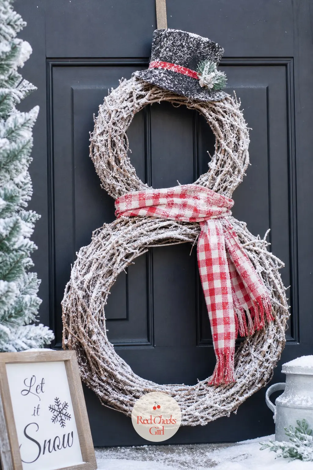 The Flocked Grapevine Snowman Wreath — Grapevine forms give this one a sturdiness the softer versions cannot match