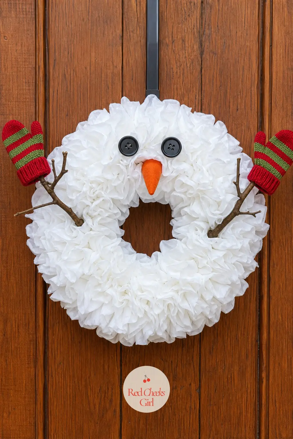 The Mitten and Twig Arm Snowman Wreath — Two real twigs pushed deep into the sides of the wreath and angled wide make this snowman look mid-wave rather than