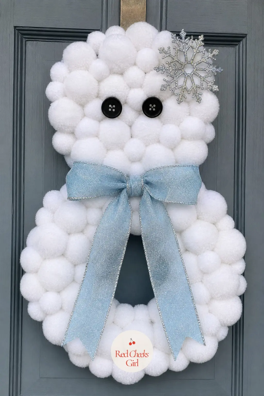 The Pom-Pom Snowball Cluster Snowman Wreath — Every inch of the double wreath form here gets covered in handmade white pom-poms instead of fabric or mesh, so
