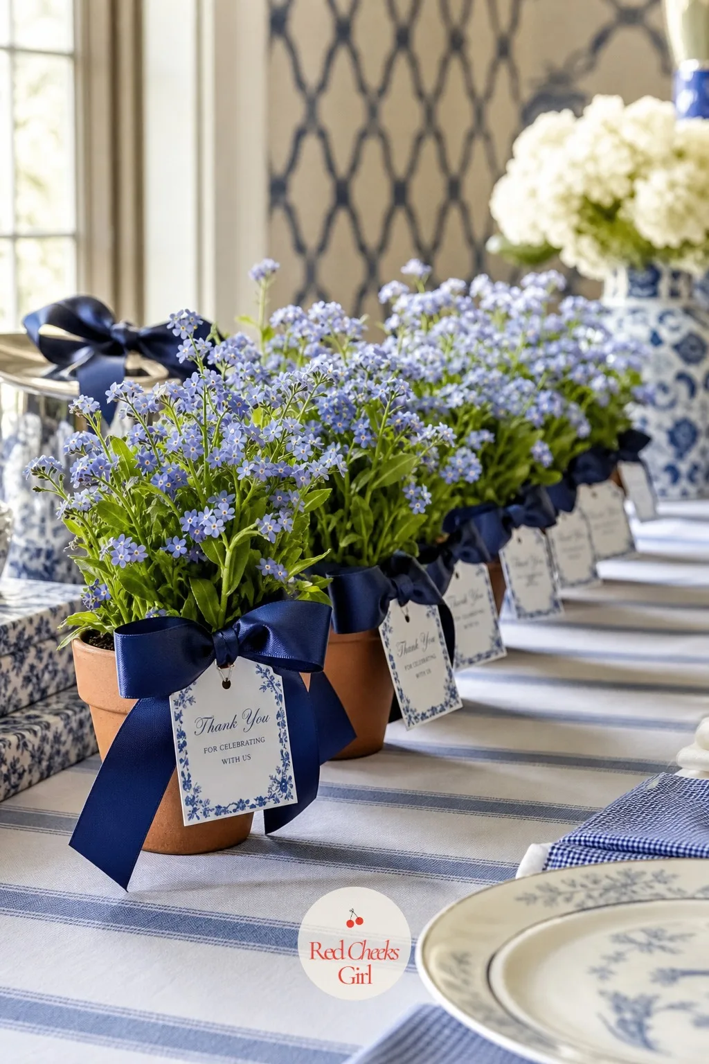 A Potted Forget-Me-Not Favor — At the far end of the favour table, a small row of potted forget-me-nots stands in for the usual bag of sweets, each one in a