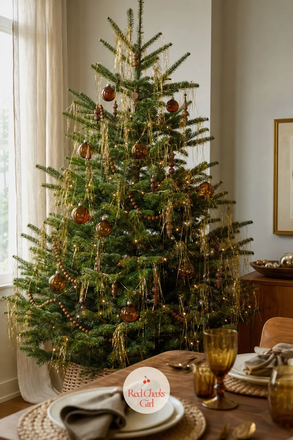 The Golden Lametta Fir — The same draped-tinsel idea in gold instead of silver, hung on a real fir in a dining room where the table does the rest of the