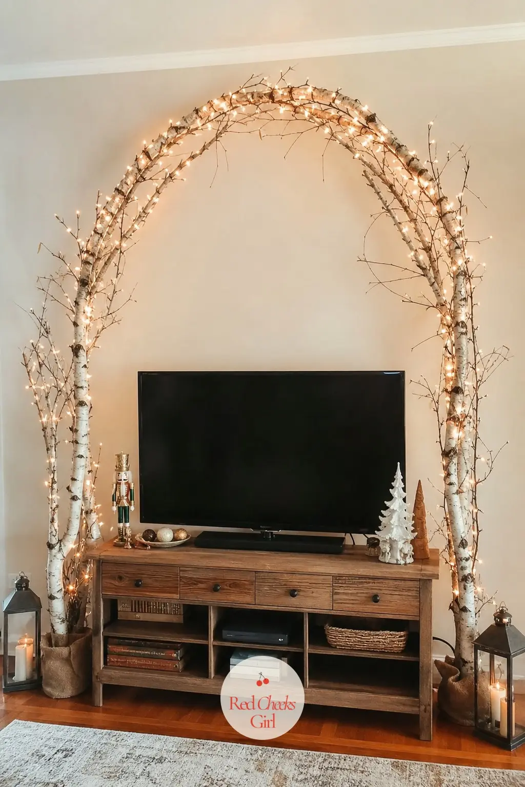 A Birch Branch Arch Strung With Copper Wire Lights Framing the Screen — Two curved birch branches meet above the screen like a shallow arch, wired together