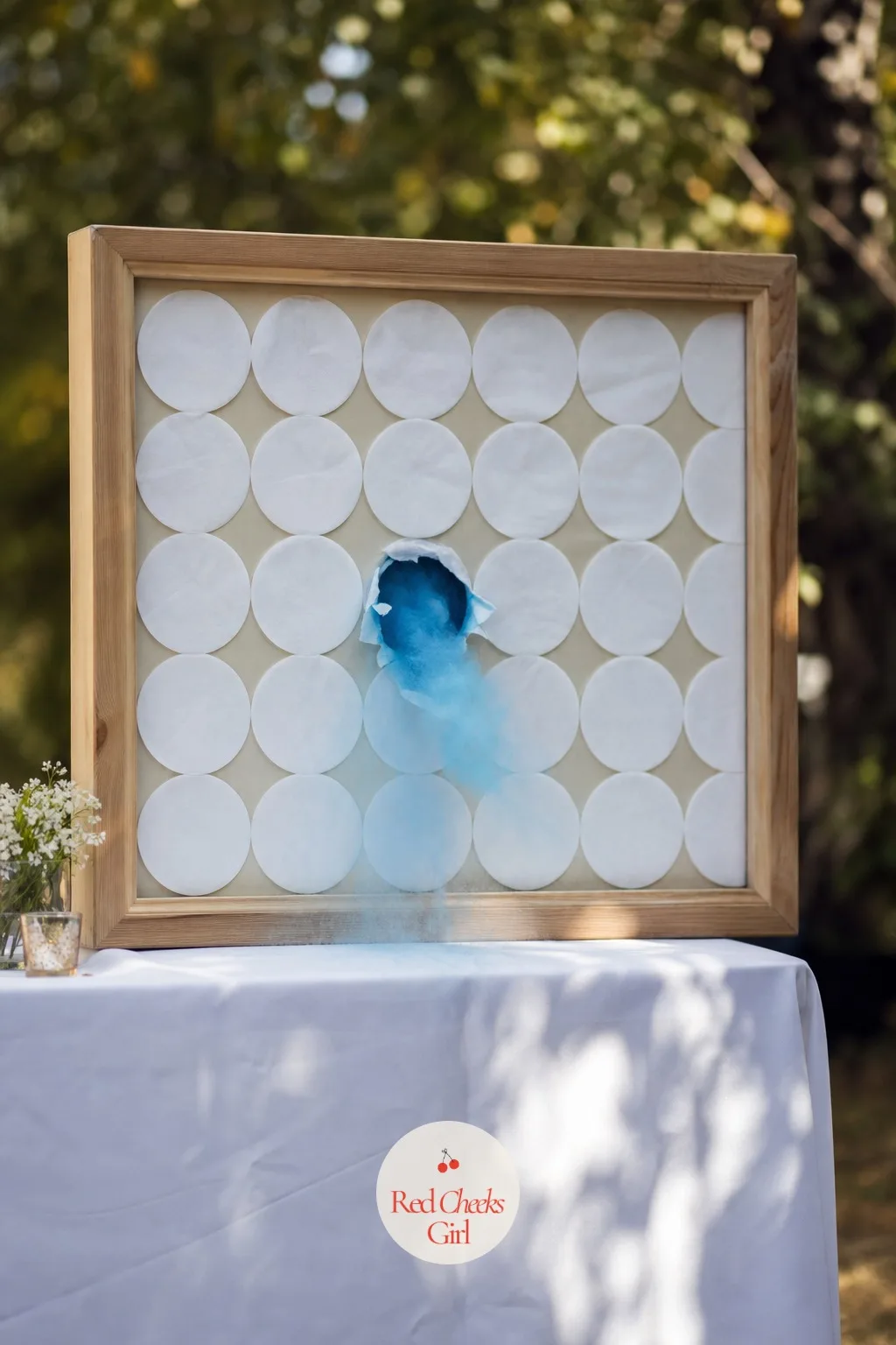 Mystery Punch Box Wall — A grid of paper-covered holes stretches across a board like an advent calendar with no dates on it, and one single square, punched