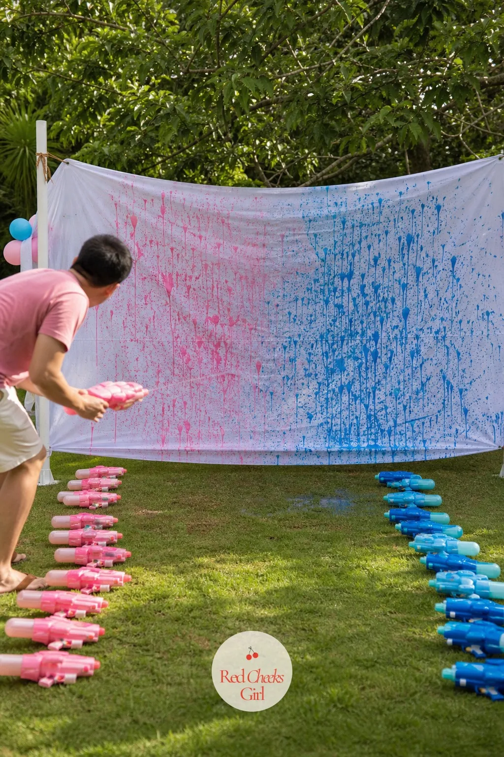 Team Blue vs Team Pink Water Gun Duel — Two camps line up across the lawn, one armed with blue-tinted water, the other with pink, soaking a blank white banner