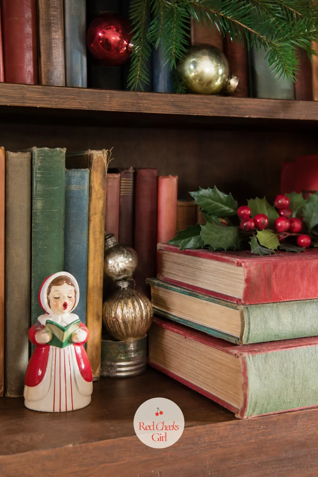 The Bookshelves, Annuals and Mercury Glass Tucked Between Books — A stack of vintage-style holiday annuals lies flat between the upright books, and a few