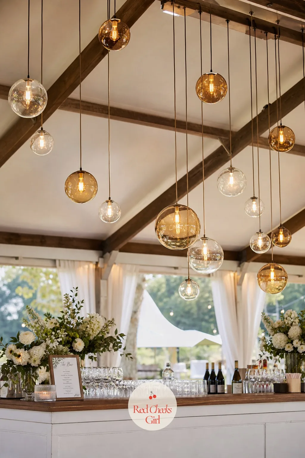 Hanging Glass Orb Lights — A flat string of lights overhead is pretty but forgettable, and a bar under a marquee has the ceiling height to do more than that.