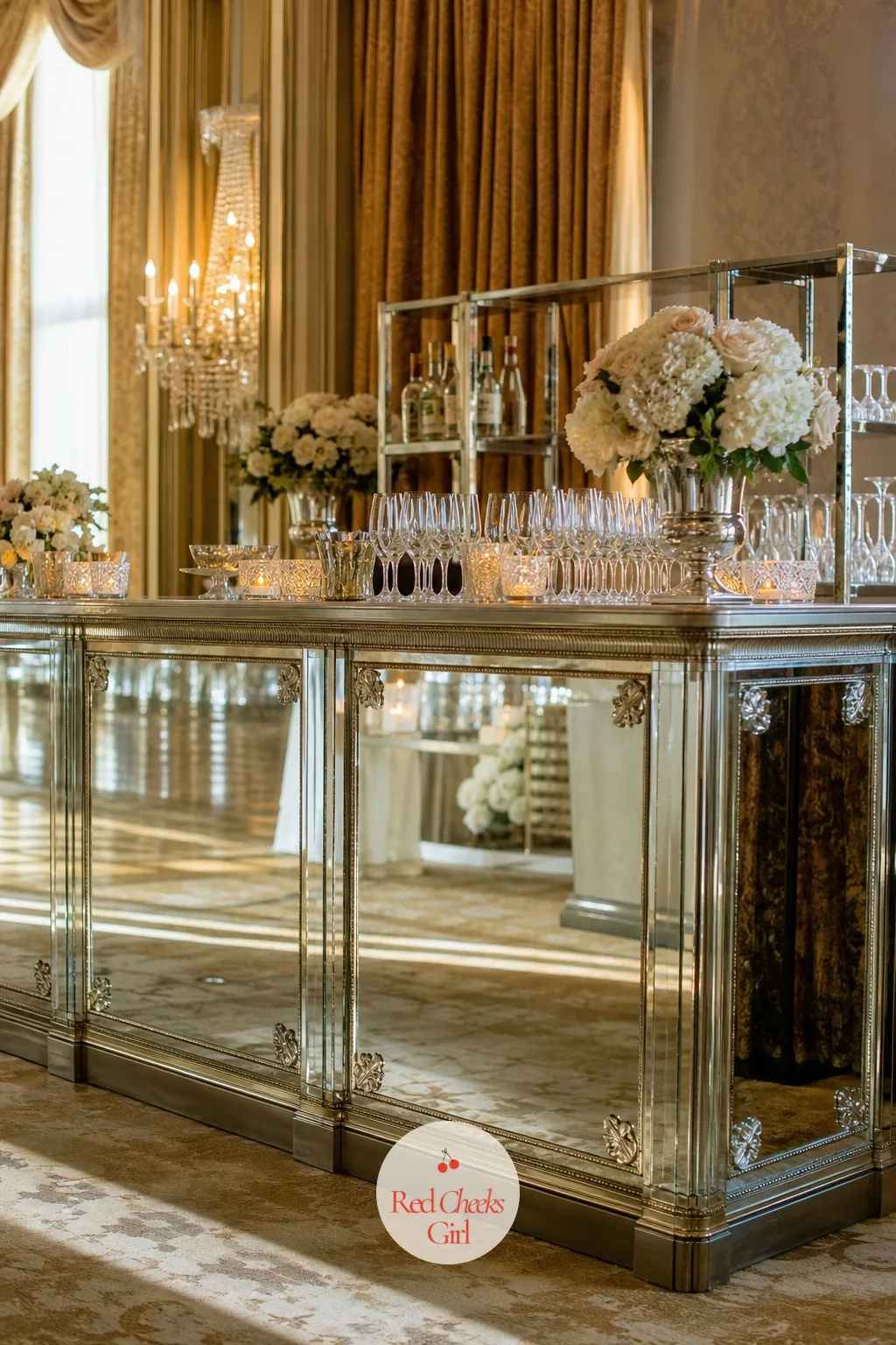 Mirrored Bar Facade — A ballroom bar under a chandelier either reflects that light or wastes it, and a plain wood front wastes it every time. Wedding bar decor
