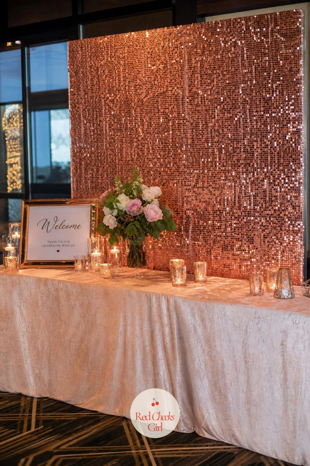 Rose Gold Sequin Backdrop for a Glam Night Entrance — Behind a welcome table in a dim room, a shimmering sequin panel catches every candle flame nearby and