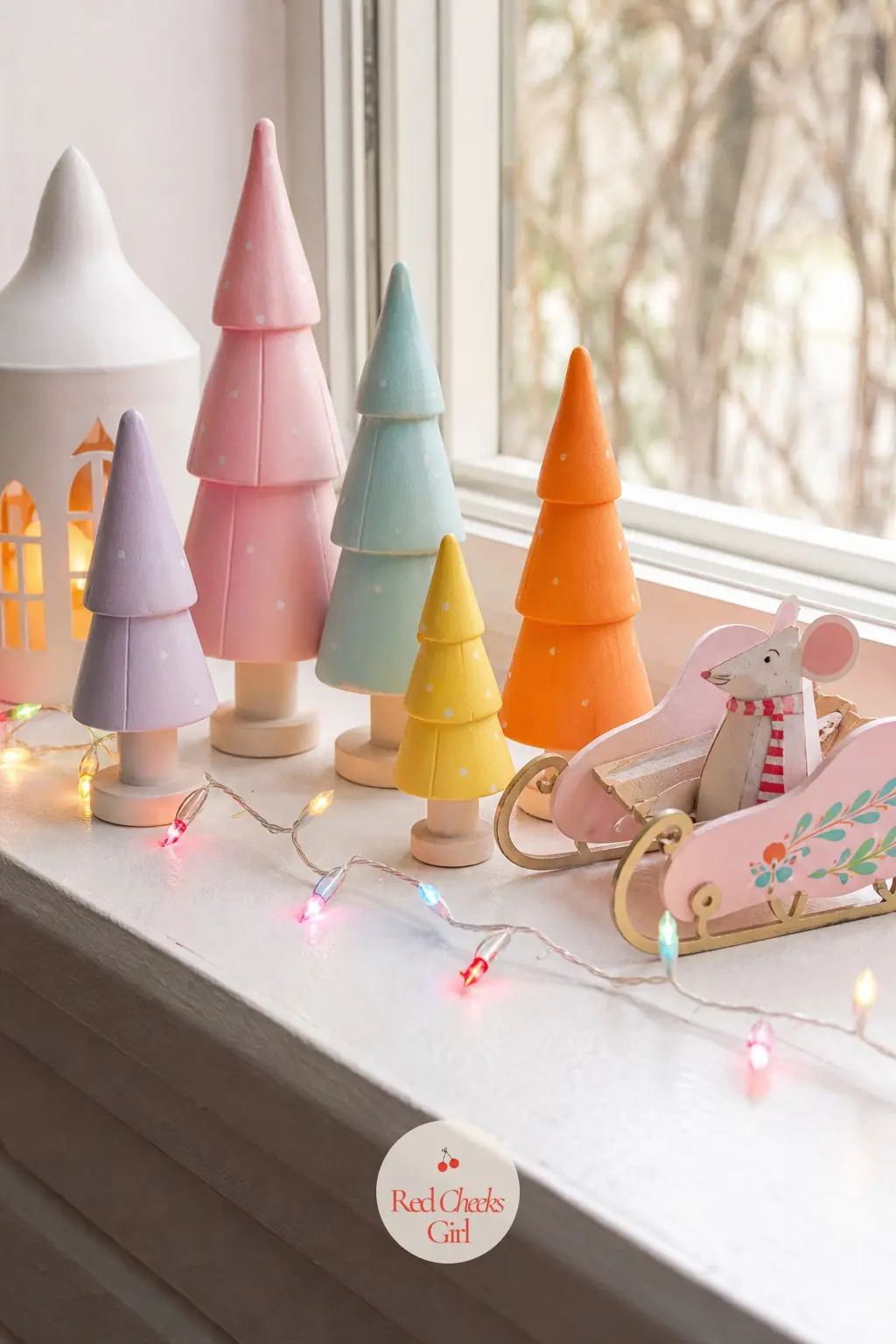 The Window Ledge Nook — A deep window ledge in a playroom or landing holds a row of small painted wooden figures in the five colours, a toy sleigh among them