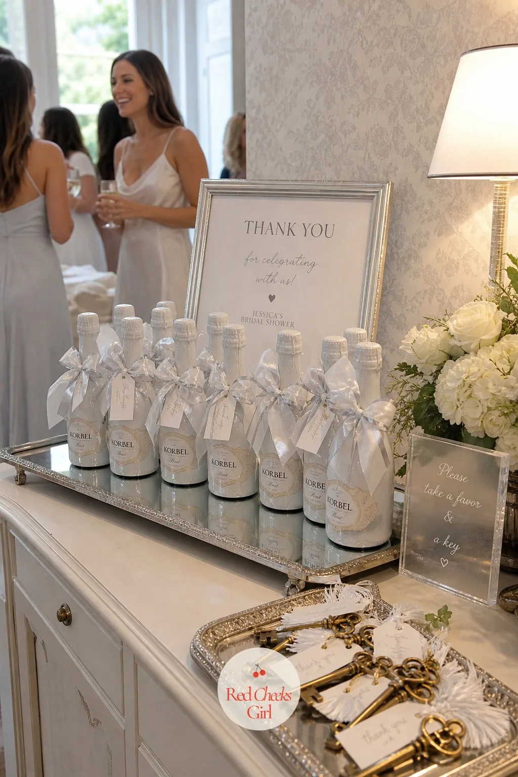 Mini Champagne Bottle Favors — Something to toast with later, once the party is over, sits alongside the brass keys on the same mirrored tray. White bridal