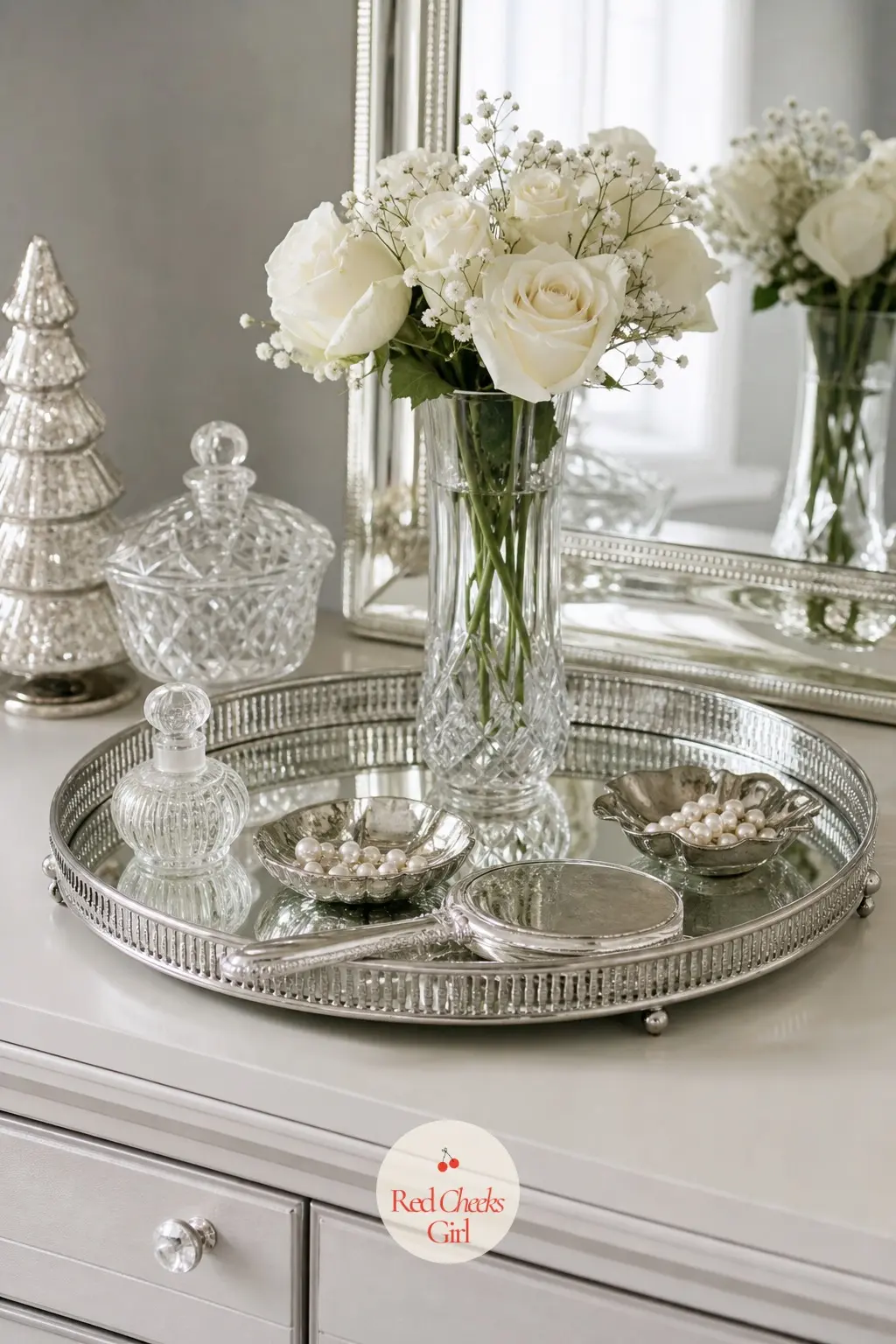The Dresser Top, Styled With a Mirror Tray — A mirrored tray gathers the small things that would otherwise scatter across the dresser: a silver hand mirror, a