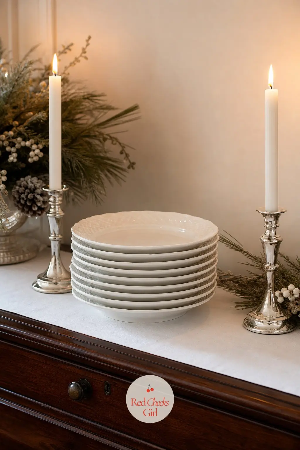 The Sideboard, Stacked in White Porcelain — Eight white dinner plates stack ready for serving, a white table runner underneath and a pair of silver