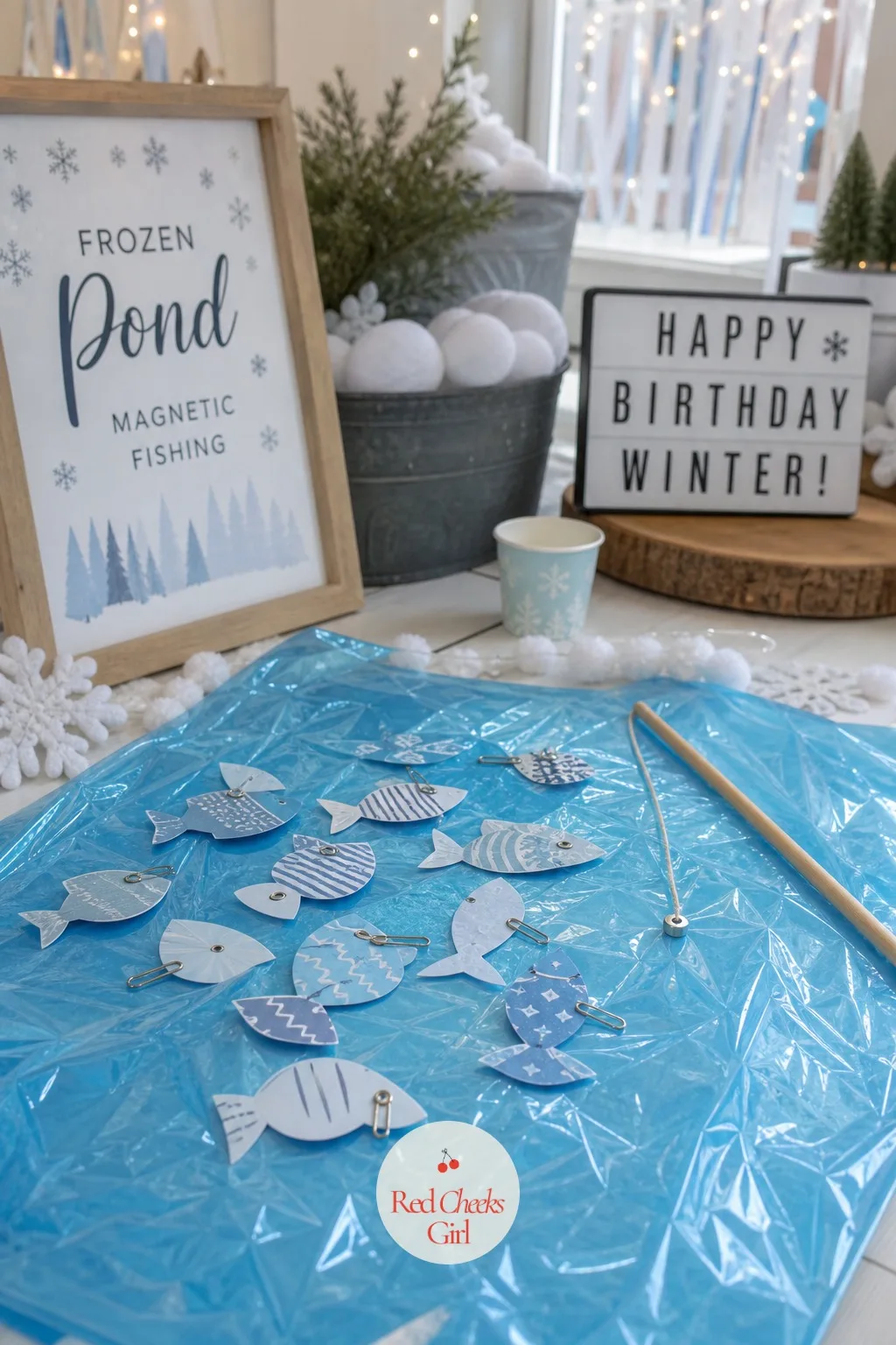 Frozen Pond Magnetic Fishing Game — A sheet of blue cellophane laid flat on the floor becomes the pond, scattered with paper fish each fitted with a paperclip