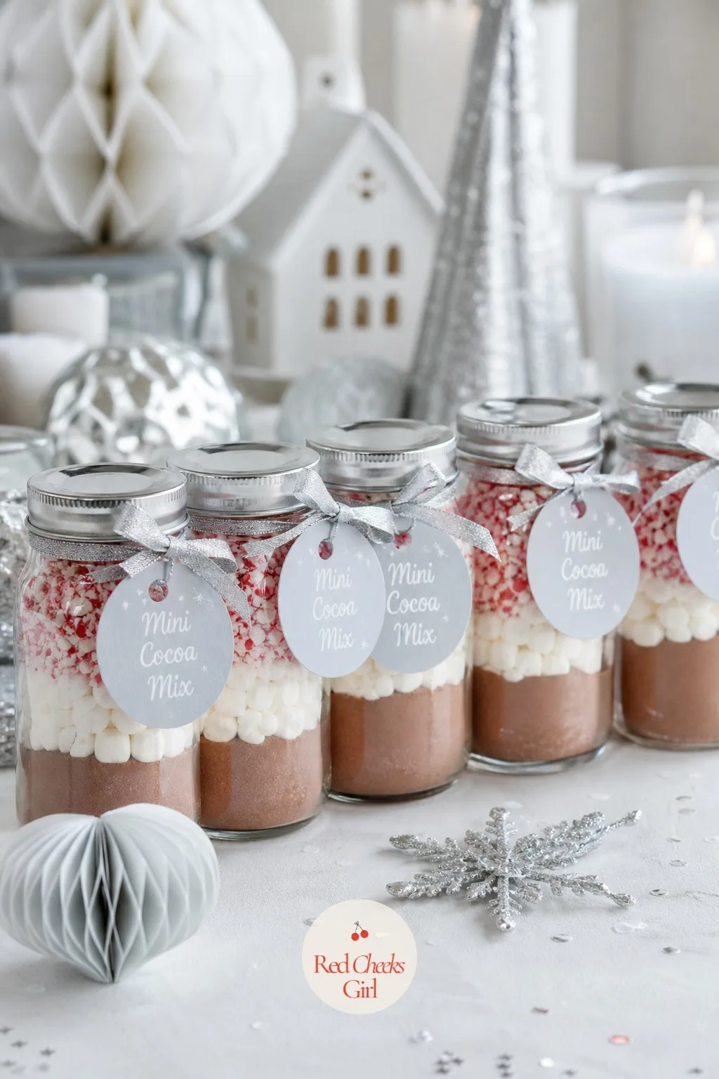 Mini Cocoa Mix Jars — Small glass jars, layered with cocoa powder, mini marshmallows and a little crushed peppermint, give guests a drink to make once they are