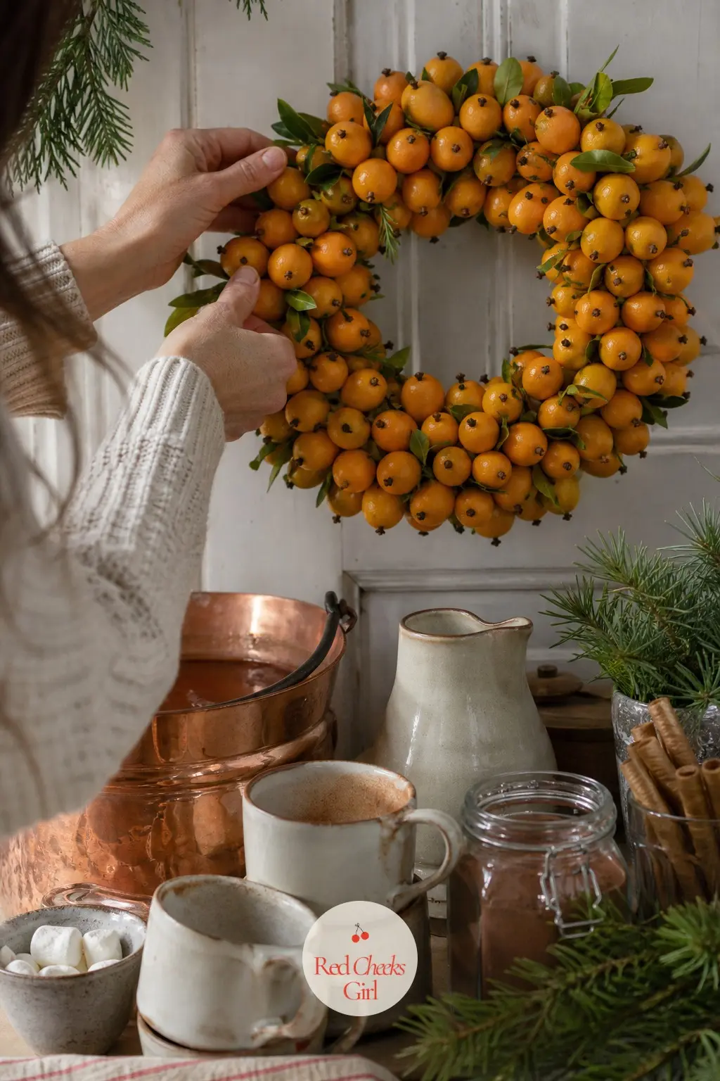 Kumquat and Clove Pomander Wreath Behind the Cocoa Station — Whole kumquats studded with cloves and threaded onto wire into a loose ring bring the smell of a