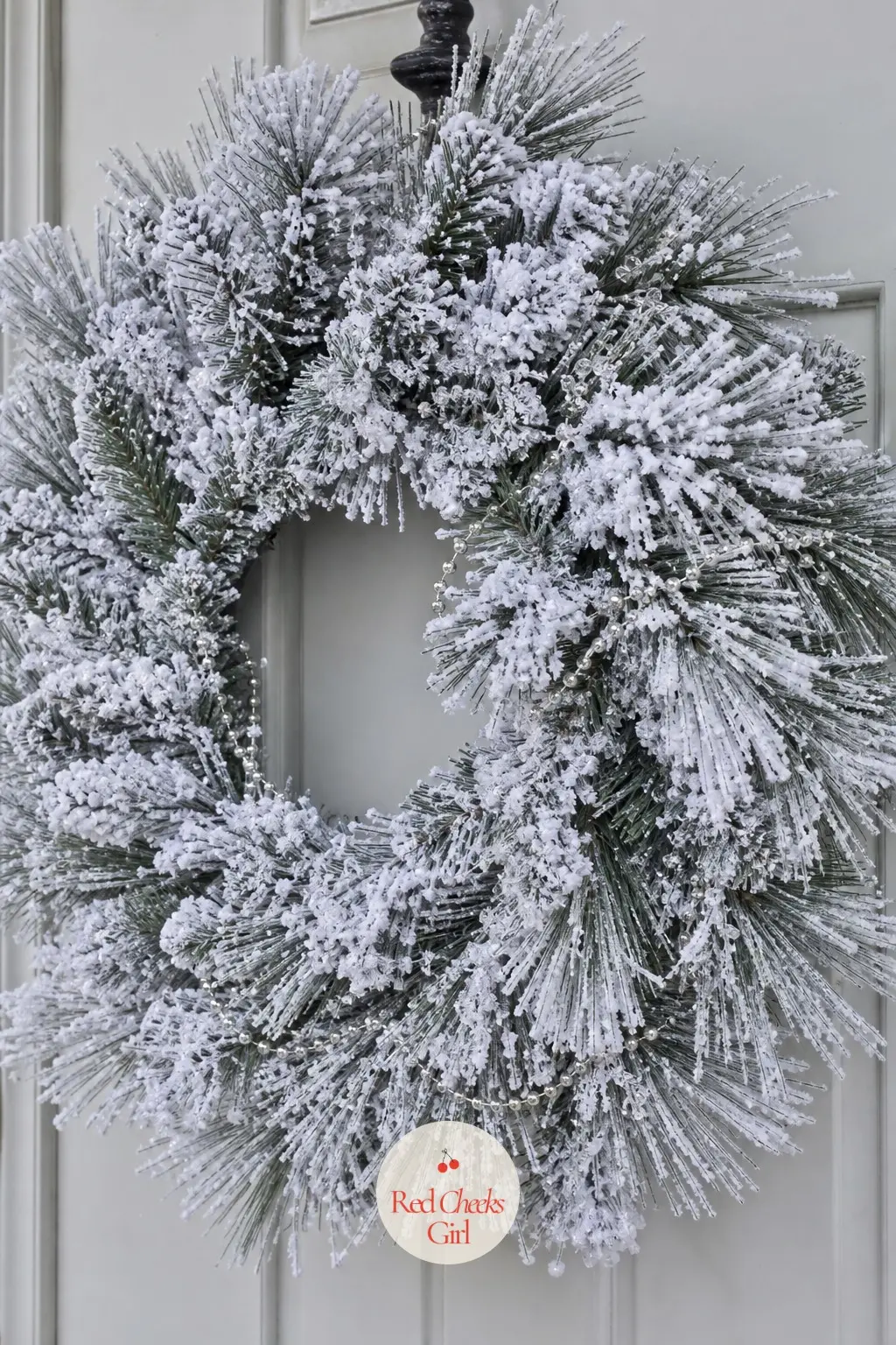 Snow-Flocked White Pine Wreath with Rock Salt Dusting — White-flocked pine holds its shape for the whole season, which is the entire argument for choosing it