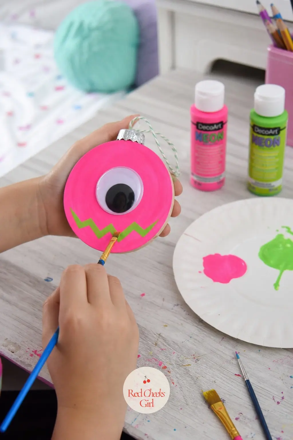 Neon Googly Monster — Neon pink base, a green zigzag mouth, and one oversized googly eye glued dead centre once the paint is fully dry. Wood ornament painting