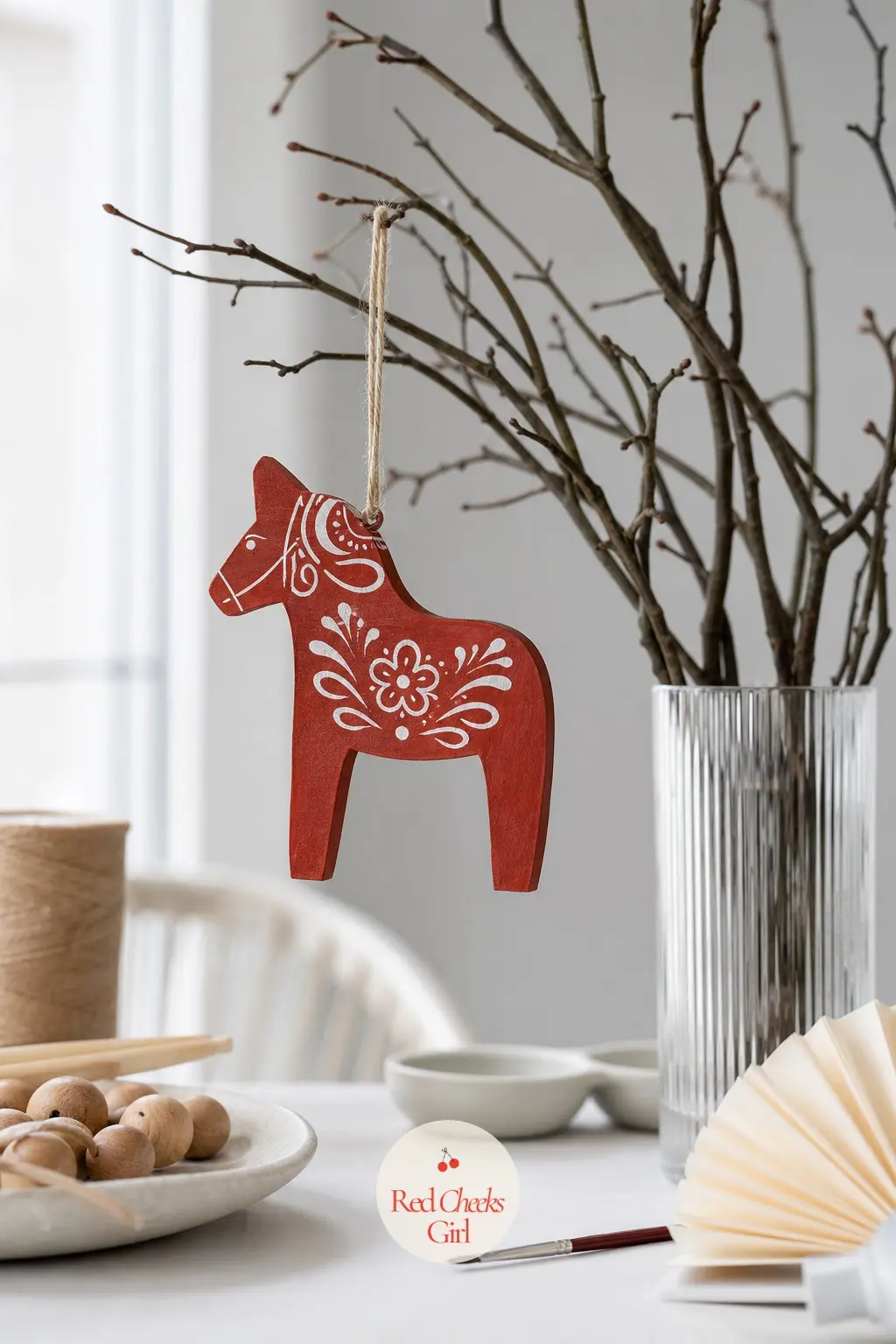 Nordic Dala Horse — The Scandinavian dala horse earns its place on any tree honestly: brick red body, white floral scrollwork across the saddle, a shape carved